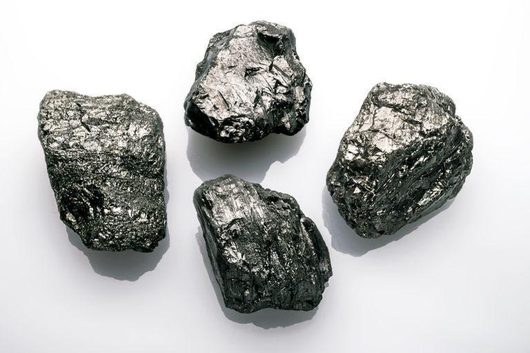 Cztery kawałki węgla na białym tle